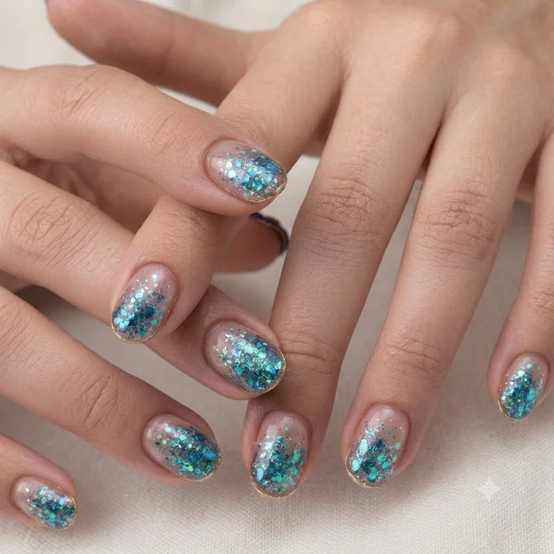 Aquarium nail design with fine glitter suspended in clear acrylic overlay in mermaid-inspired blue-green tones