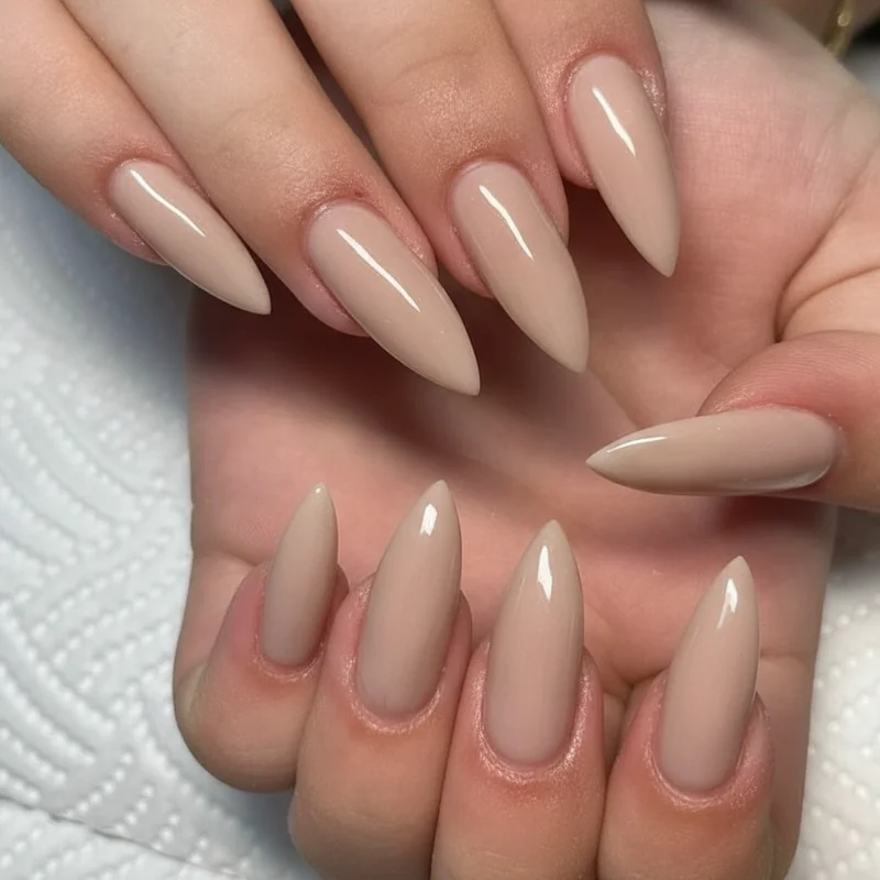 Short quiet luxury nails on soft almond shape at natural fingertip length with milky gloss finish proving length is not required for expensive look
