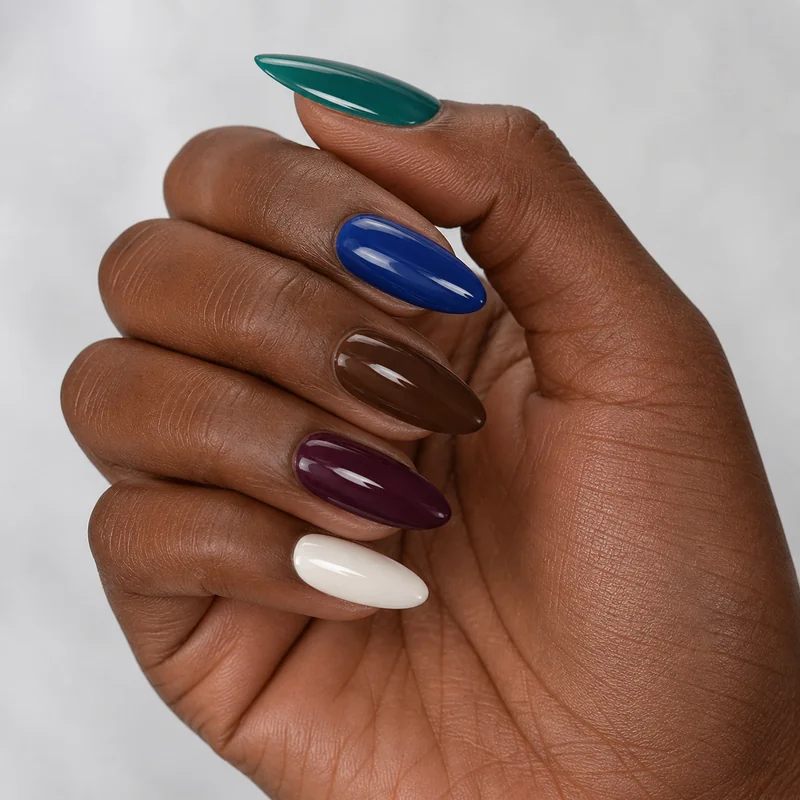Best nail colours for dark skin almond nails showing emerald green cobalt blue chocolate brown plum and true white shades that pop on deep complexions