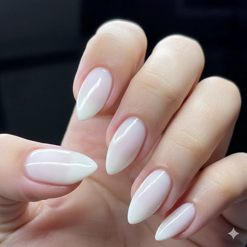 Milky glazed almond nails in Cloud Dancer porcelain shade showing quiet luxury sheer glass finish with warm light reflection detail