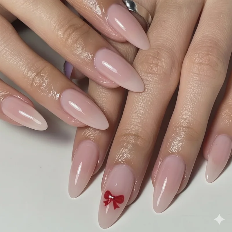 Coquette college nails with delicate red bow detail on a sheer blush base manicure