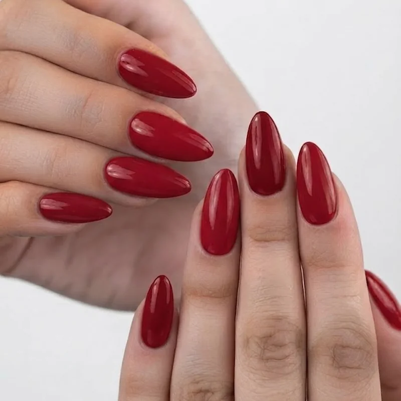 Blue-based cherry red manicure on pale skin, a flattering red for pink undertone skin tones