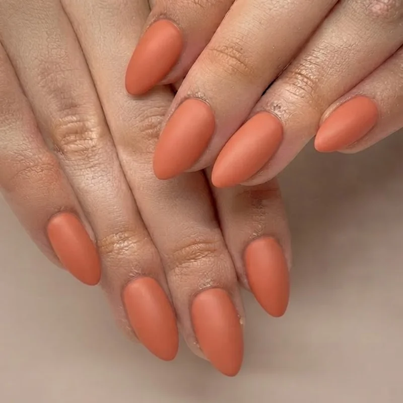 Warm caramel nude manicure on tan skin in natural daylight, everyday nail color