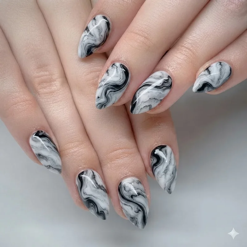 Abstract marble swirl black and white nail design flowing across almond shape nails