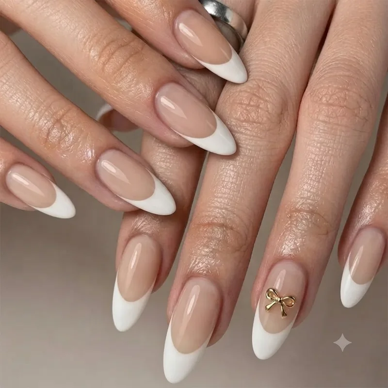 Simple bow nail art idea with a small bow charm centred on a French tip manicure