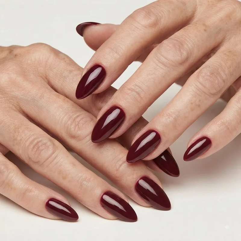 Deep garnet burgundy glossy Christmas manicure with vintage old Hollywood elegance on mature hands