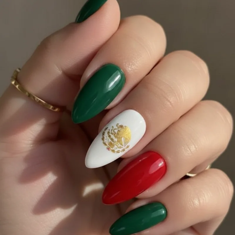 Mexican flag nails showing green white and red colour block with gold eagle accent detail on short nails for Cinco de Mayo celebration