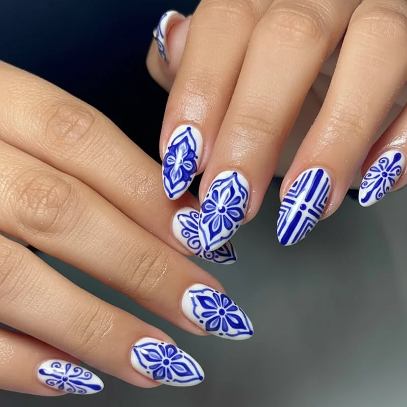 Talavera tile nails showing cobalt blue hand painted floral and geometric motifs on white base inspired by Puebla Mexico pottery tradition for Cinco de Mayo
