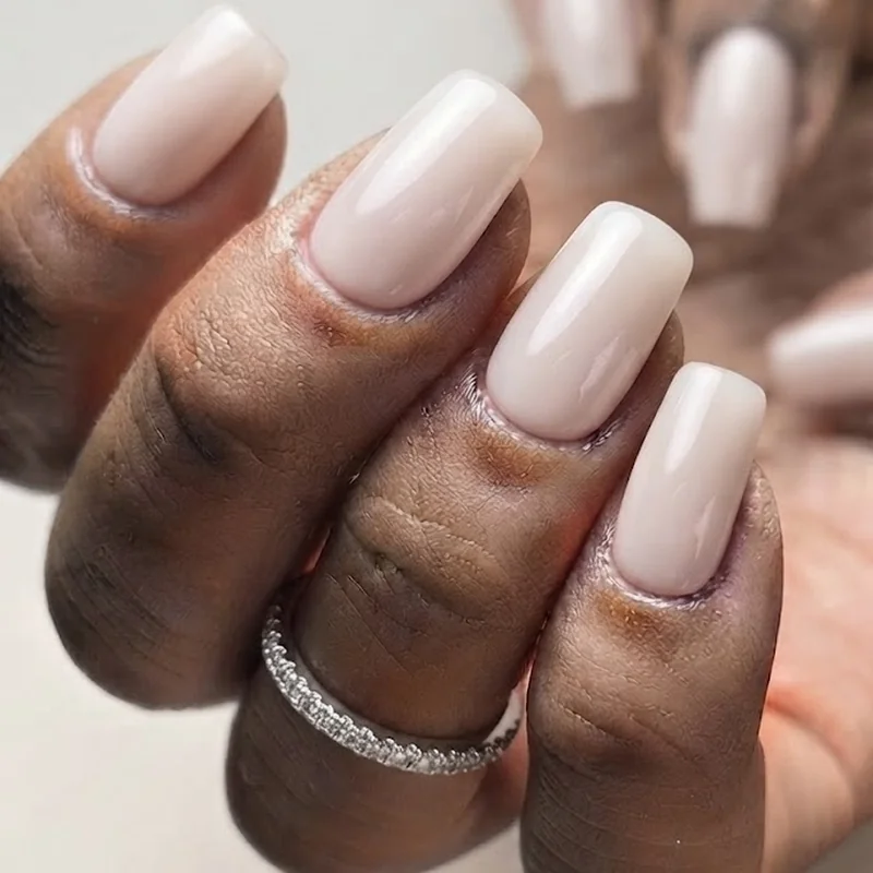 Glazed milky white nude manicure on short square nails with high-gloss finish