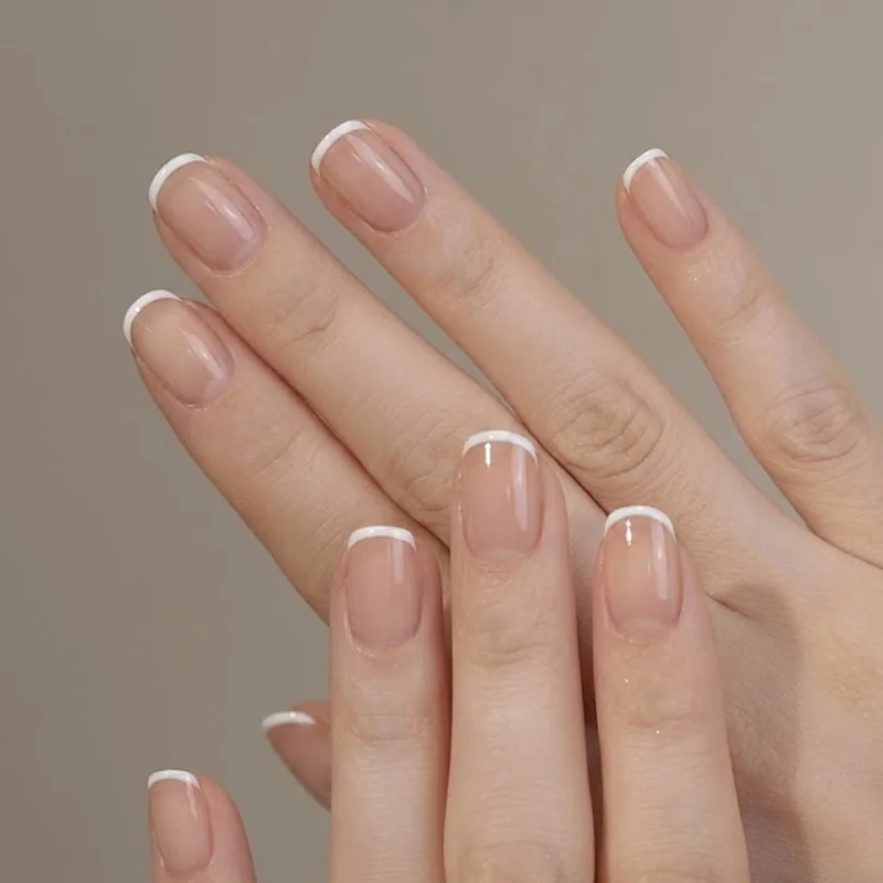 Ultra-thin micro french tip in white on sheer nude base, short nail length