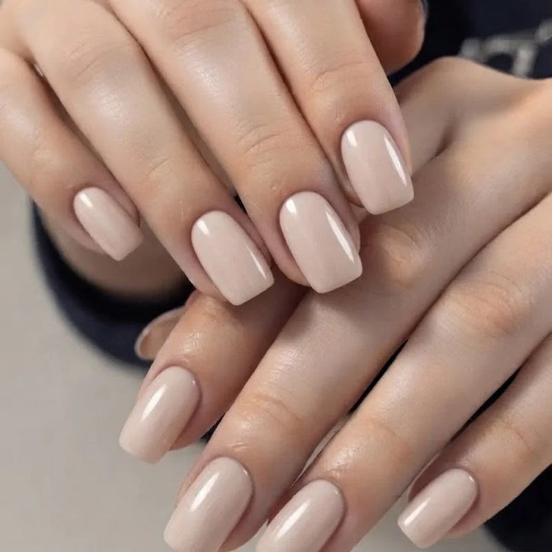 Short squoval and almond nail shape comparison in glossy nude manicure with clean cuticle line