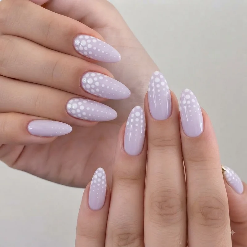 Graduated polka dot pattern on pastel almond nails following the tapered nail shape