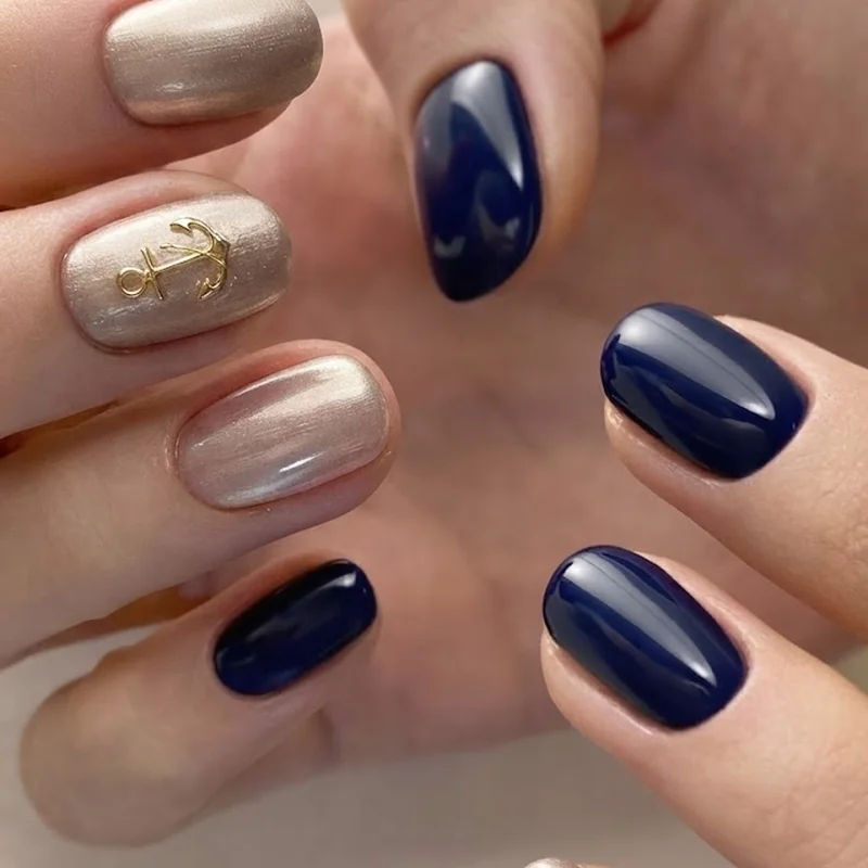 Navy and champagne metallic nails with a tiny gold anchor accent for Disney cruise formal night