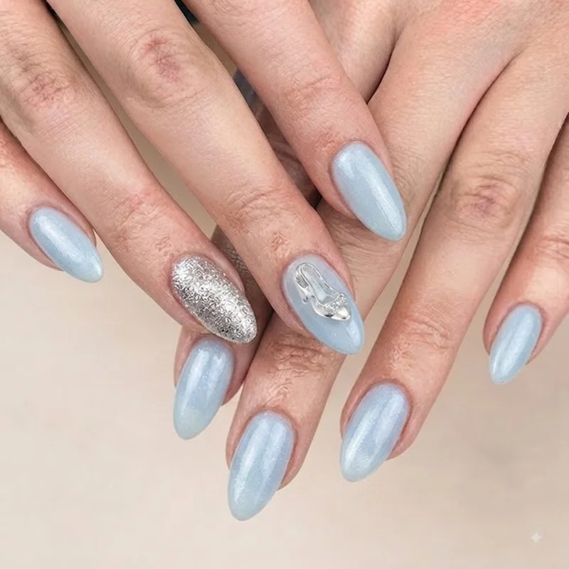 Cinderella-inspired ice blue almond nails with silver glitter accent nail and glass slipper detail