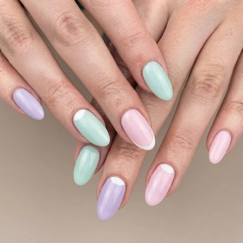 Pastel mickey mouse nails in soft lavender, mint, and baby pink tones with gentle white character detail, spring manicure