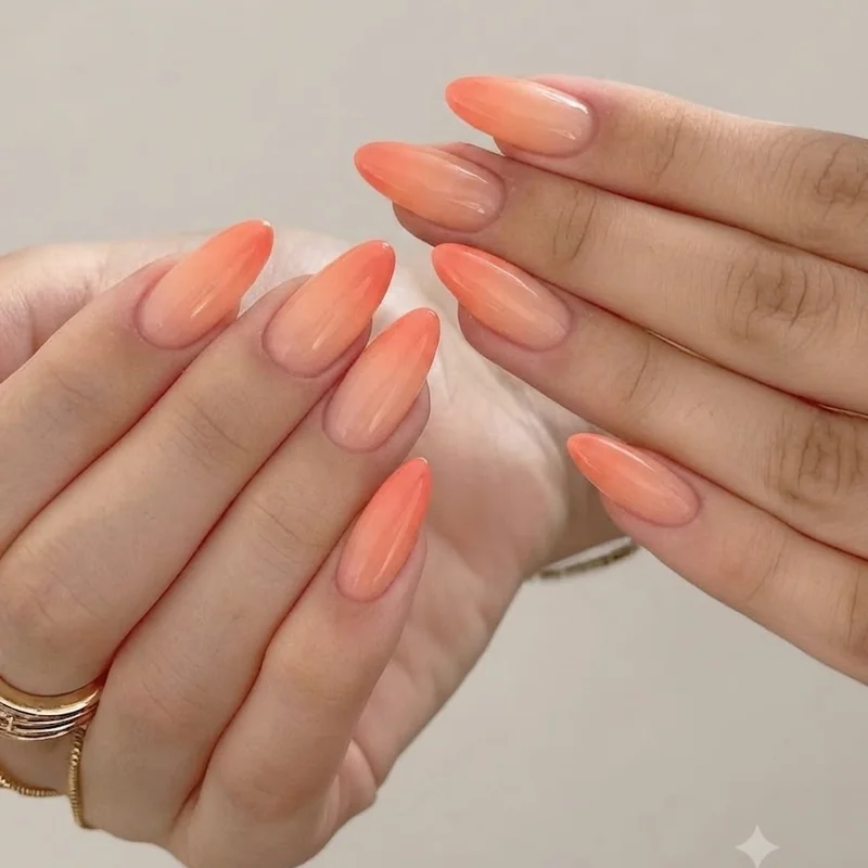 Sunset ombré manicure with warm gradient from peach to coral across the fingertips