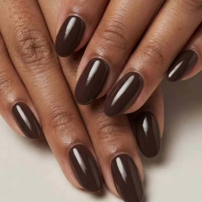 Glossy brown nail polish for fall shown on medium to deep skin tone with a high-shine finish