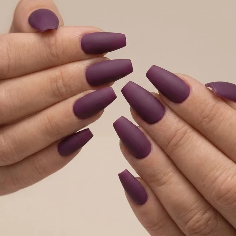 Warm terracotta manicure fall 2026 against a cozy knit sweater backdrop with matte crème finish