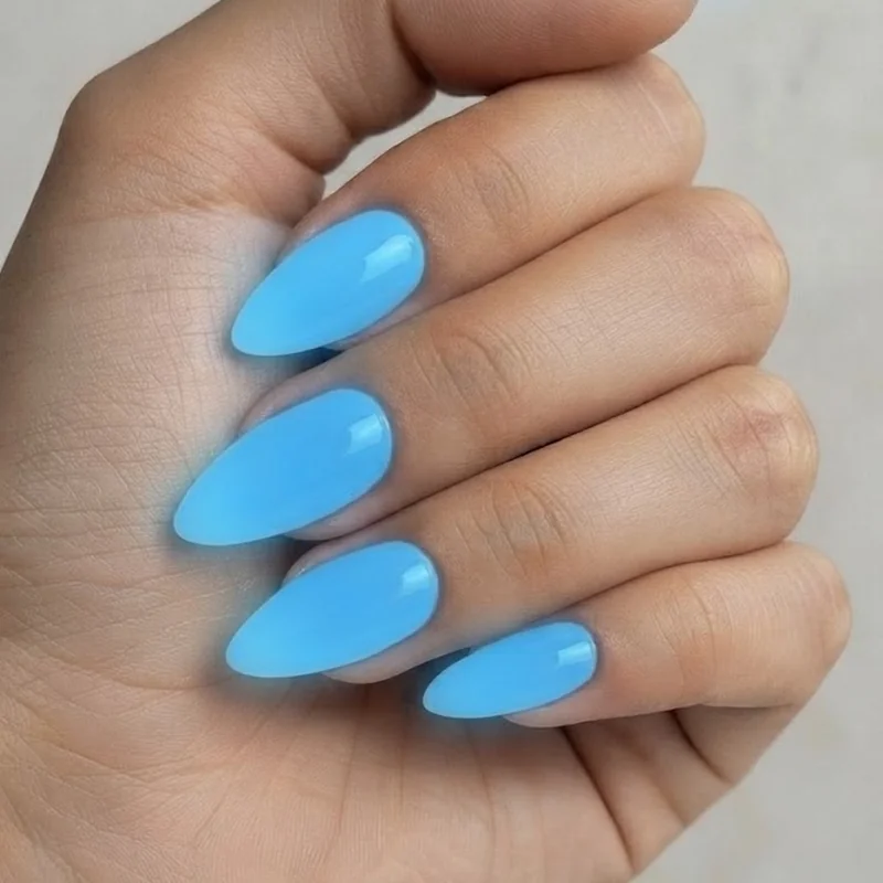Close-up of glow-in-the-dark topcoat nail design holding a soft blue glow