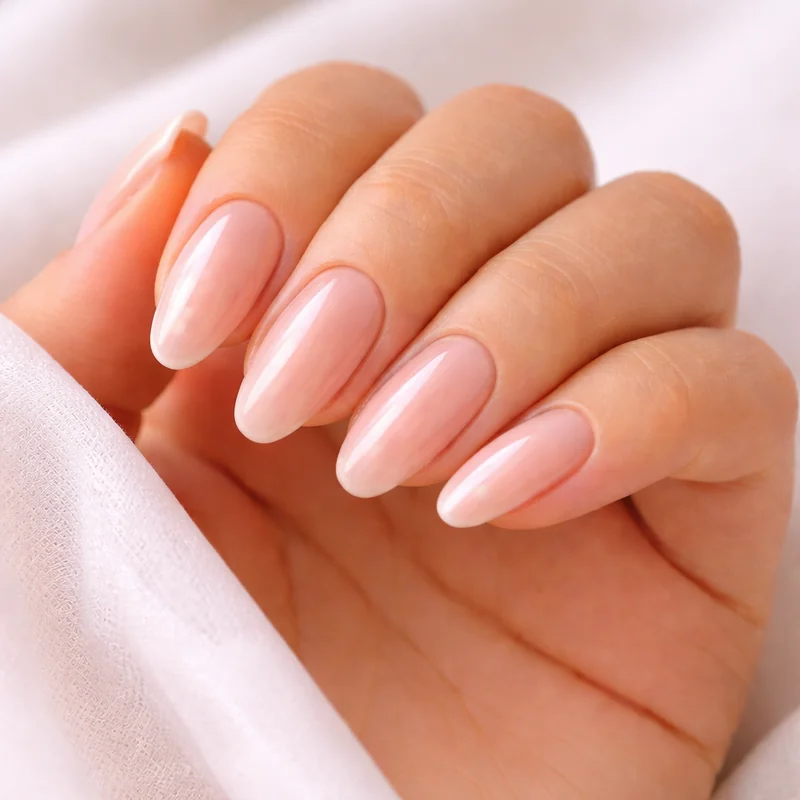 Gel-X almond nails showing translucent natural finish with sheer pink glazed effect highlighting the clarity difference from acrylic systems