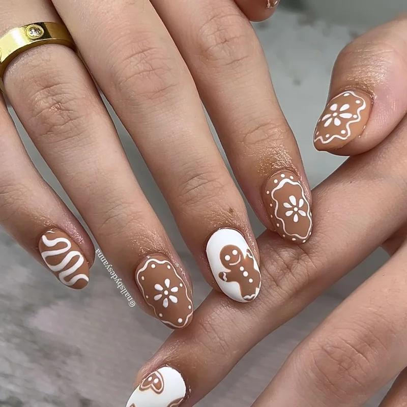 Gingerbread man nail design with brown base and white icing decorative details