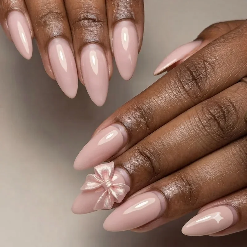Close-up of a 3D sculpted satin bow nail built with structure gel on coquette manicure