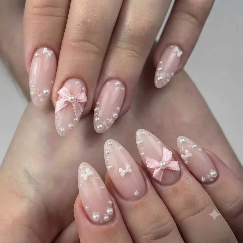 Pearl and bow coquette adjacent nail design shown for girly nails style comparison