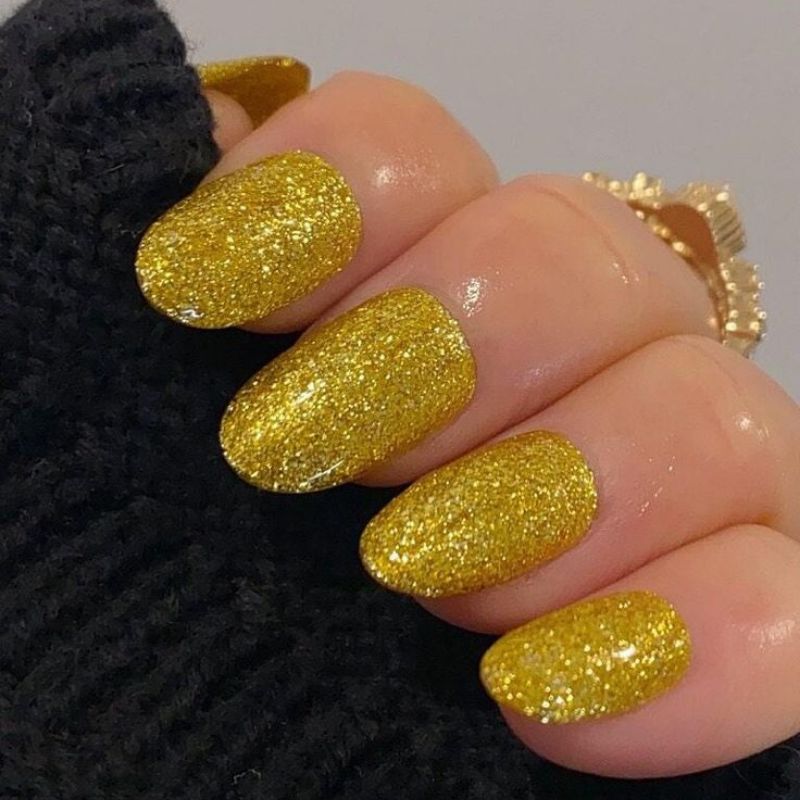 Gold metallic manicure with confetti nail art perfect for NYE celebration