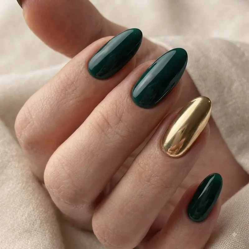 Emerald green nails with a gold chrome accent nail and glossy finish on almond shape