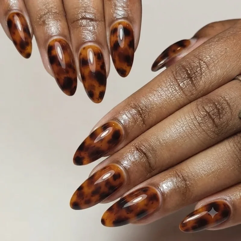 90s nail trends tortoiseshell nail art with mottled brown and amber print