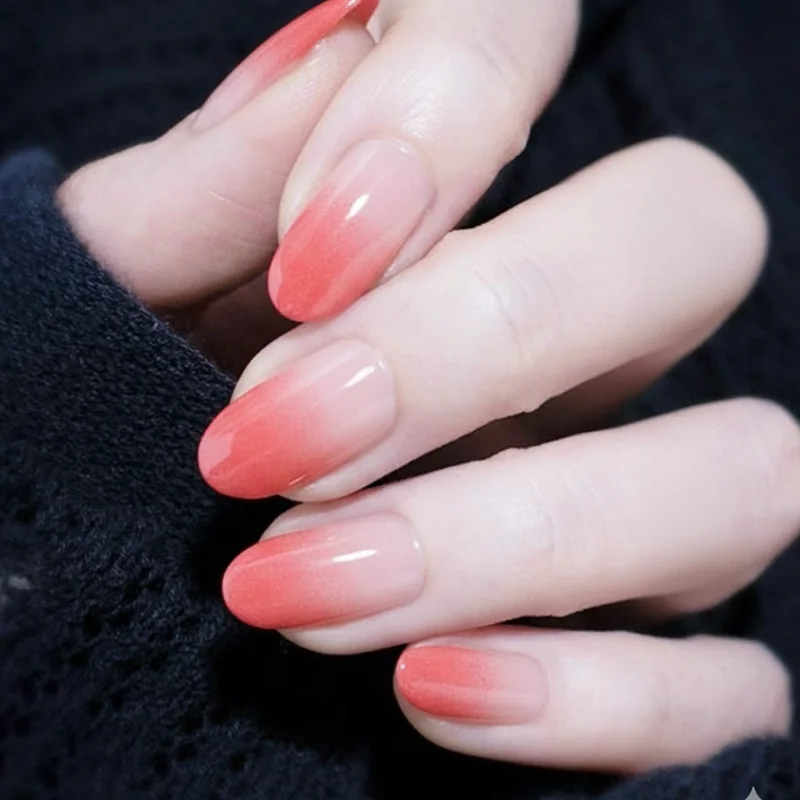 Sponge ombre technique showing coral and nude regular polish applied in thin dabbing layers building gradient from tip to base