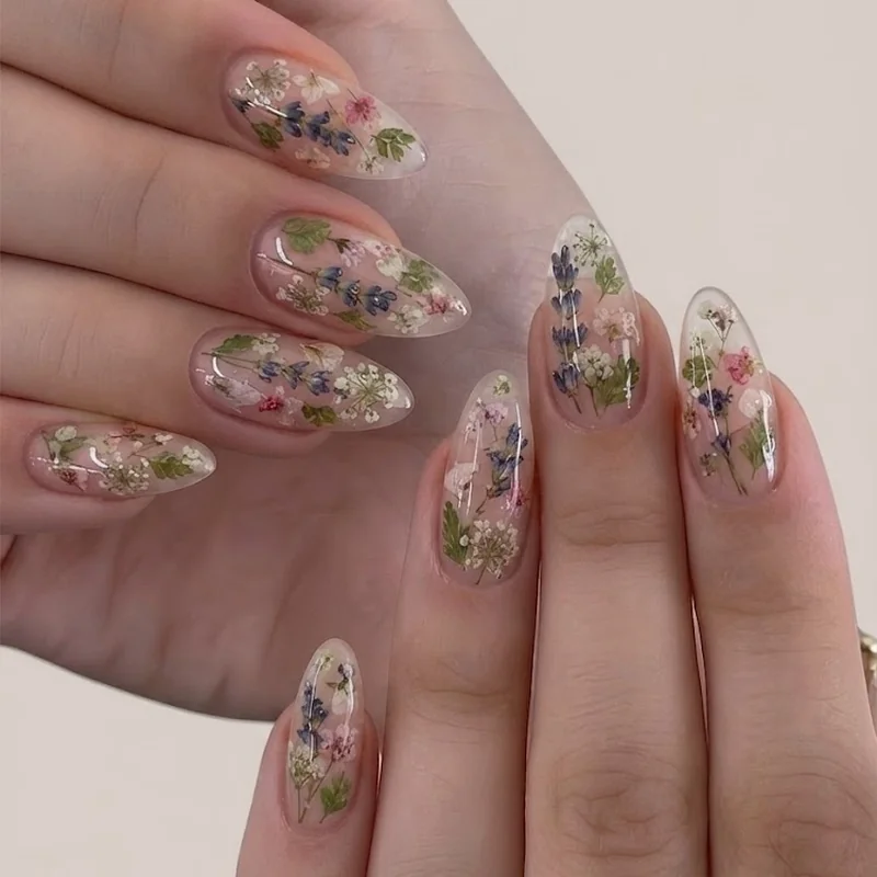 Intricate manicure designs with encapsulated pressed florals sealed under clear gel nail finish