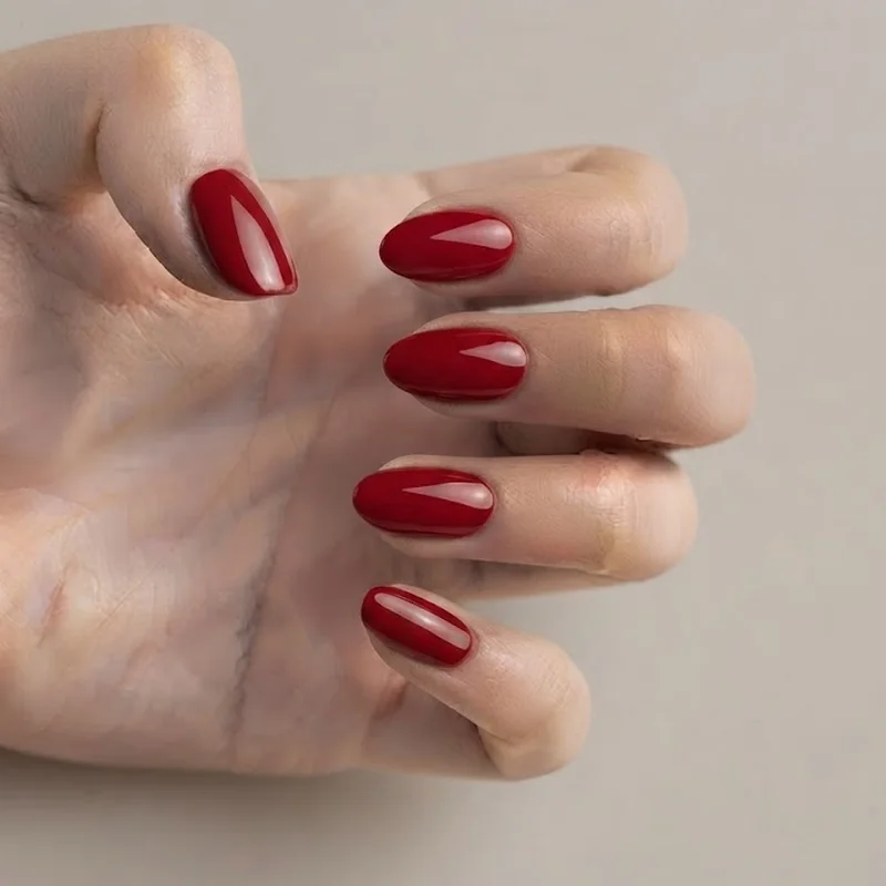 Bichota red glossy almond manicure with high-shine top coat editorial nail photography