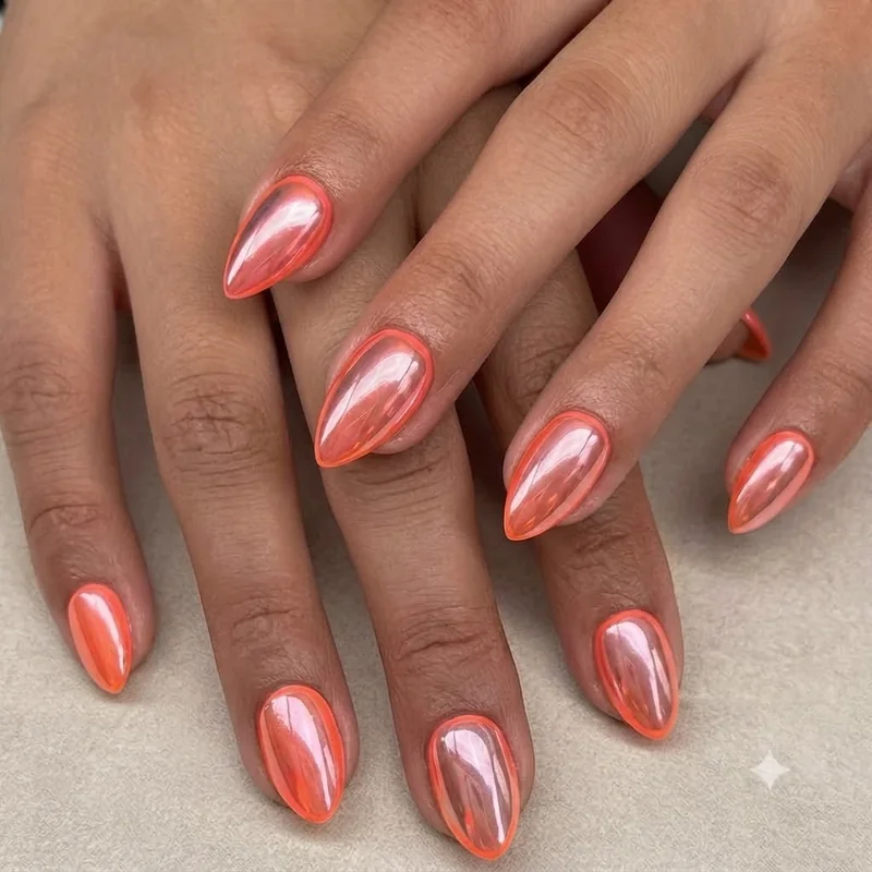 Chrome finish neon stiletto nails showing mirror effect topcoat over fluorescent base colour
