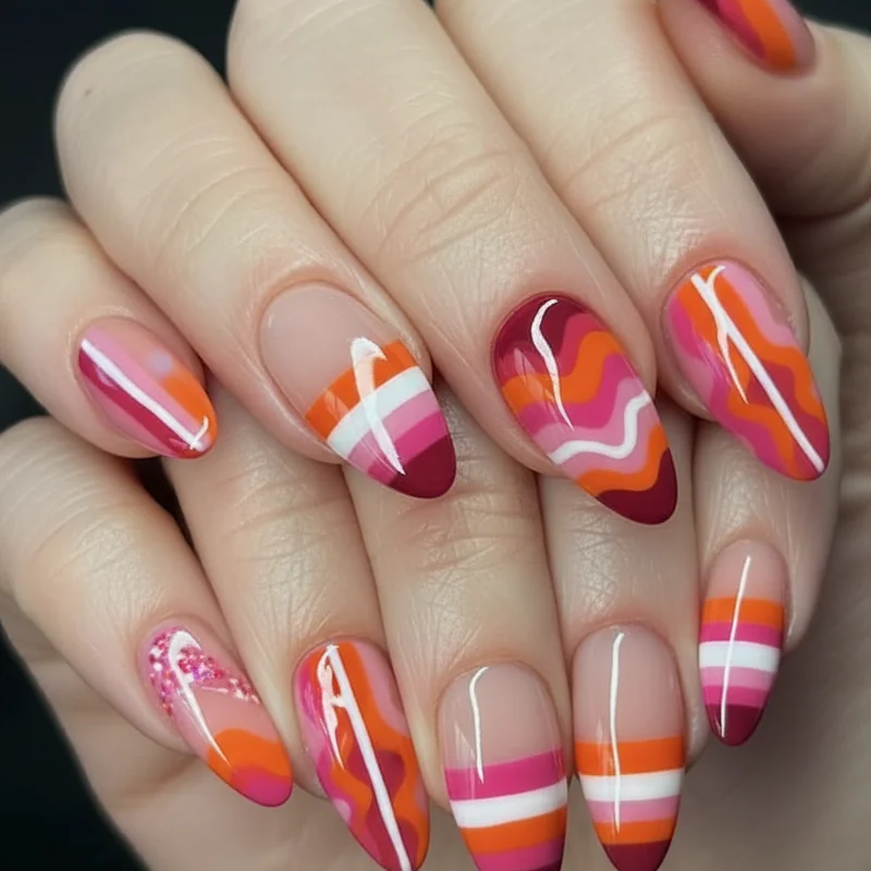 WLW couple coordinated nail set with shared sunset palette in different finishes and mismatched designs for lesbian Pride 2026