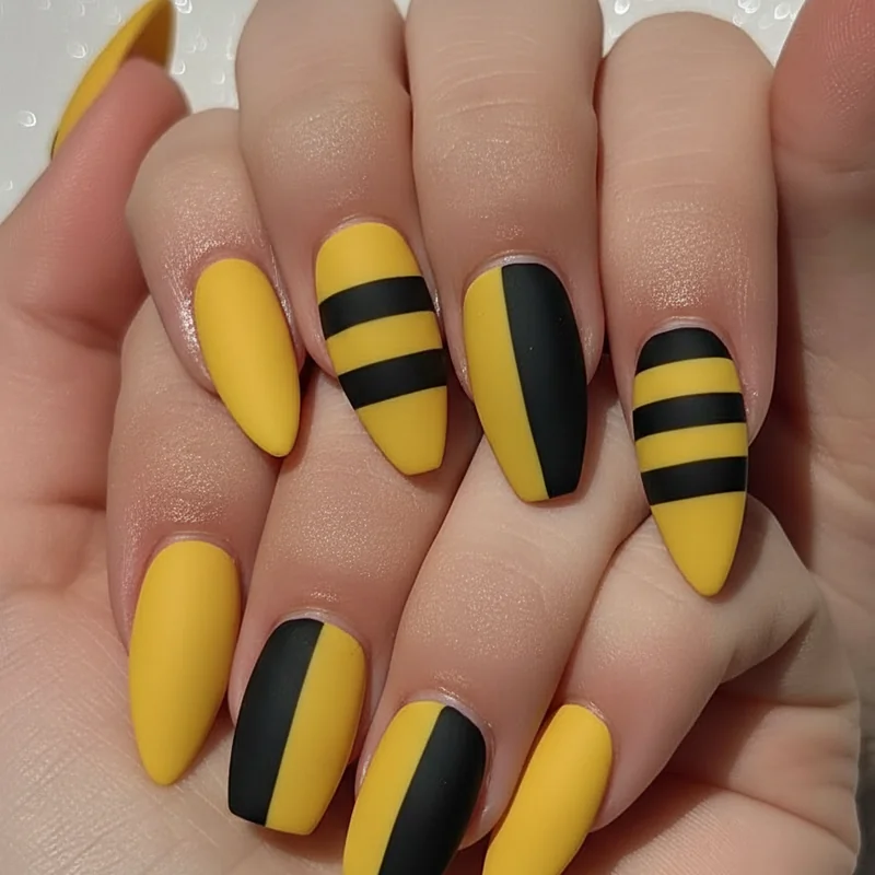Nonbinary nails for short nails and masc presentation showing matte yellow and black square squoval shapes with minimal enby stripe accent design