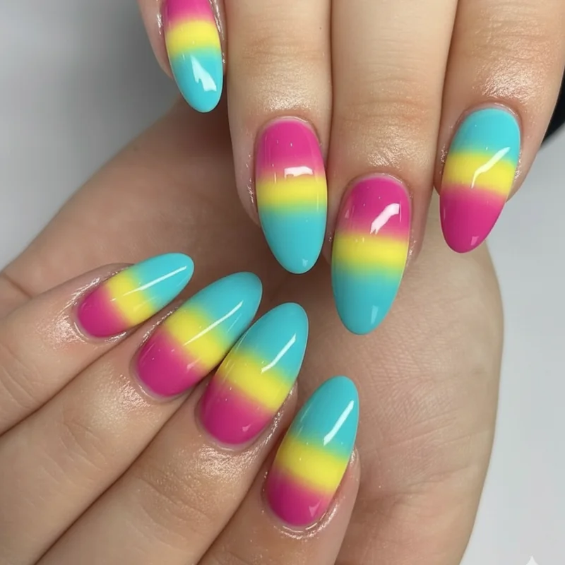 Pansexual nails showing pink yellow and cyan blue ombre gradient blending pan flag colours from cuticle to tip on medium length almond nails