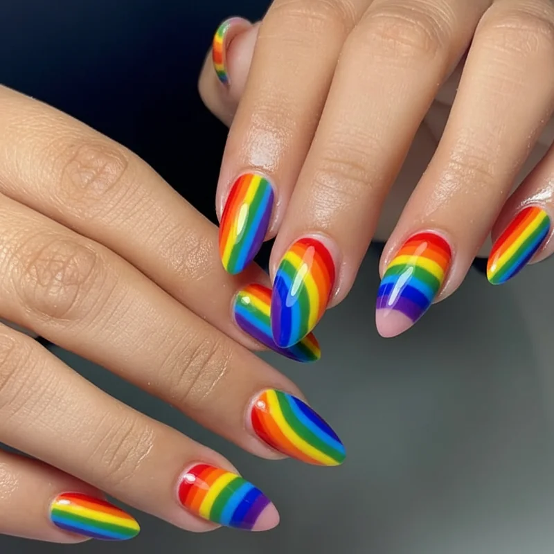 Acrylic nail extension showing monomer polymer hardened surface as canvas for multi-colour pride nail art application detail