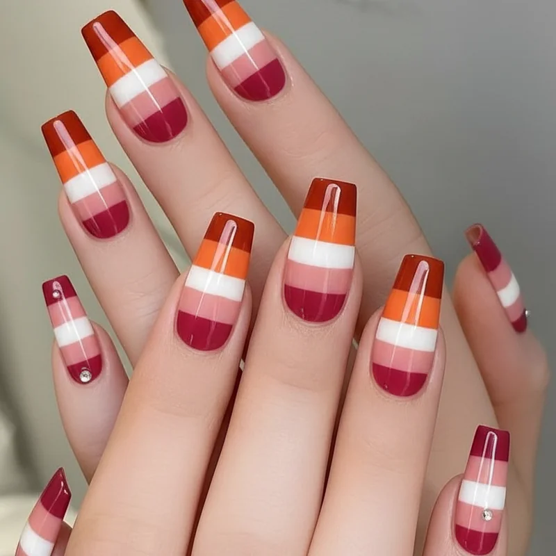 Lesbian flag nail design showing accurate dark orange white and dark rose stripe colours across five finger manicure set