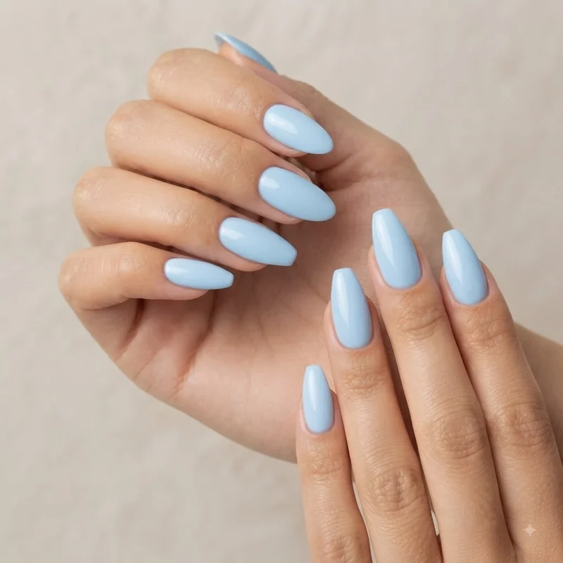 Light blue nails in almond and coffin shape showing how the tapered tip elongates the finger