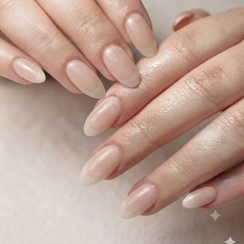 Milky nude simple nail design for long nails in a glossy almond shape with sheer translucent finish