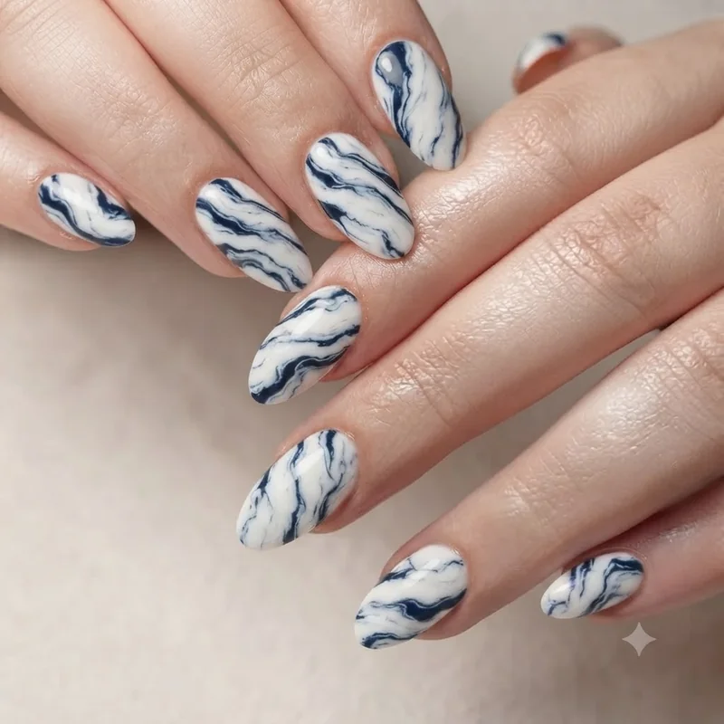 Crisp, non-muddy marble nail swirl in high-contrast white and navy demonstrating the fixed, corrected marbling result