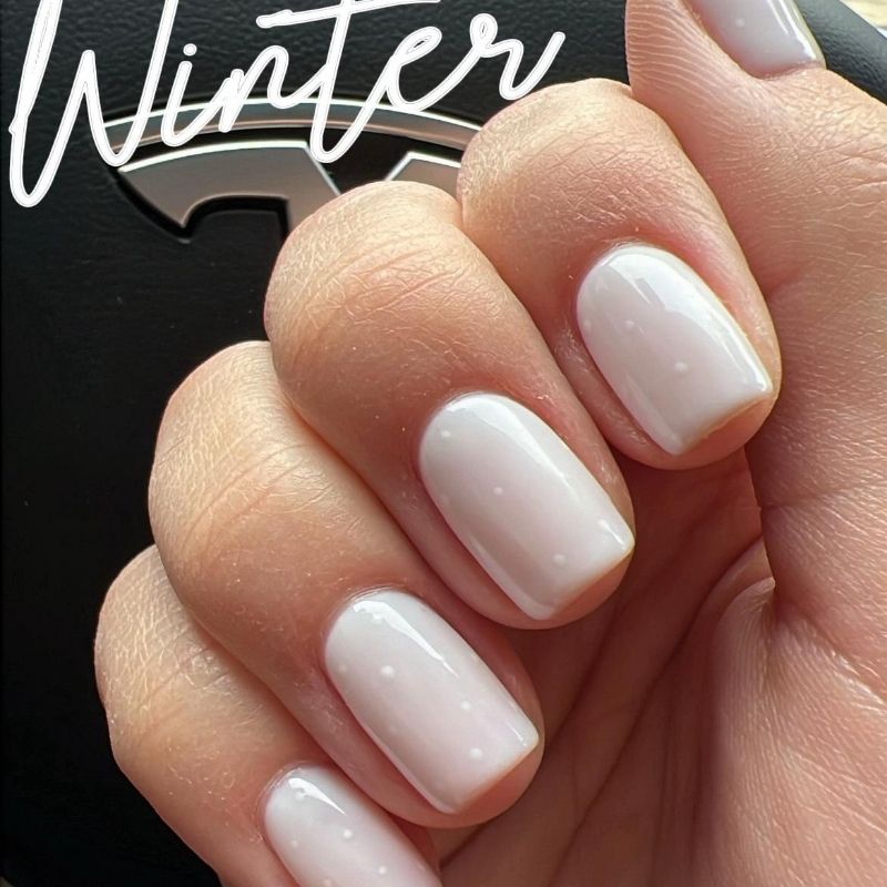 matte frosty finish being applied to white winter nails showing proper technique for snow-like texture effect
