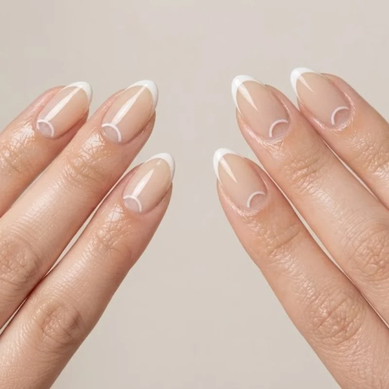 Negative space half moon dot nail design showing bare nail base with dot accent placement