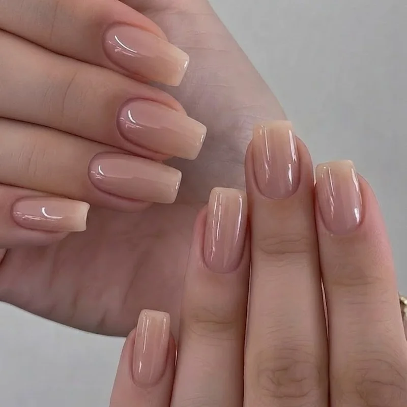 Squoval shaped short nails in sheer nude polish showing the balanced flat edge