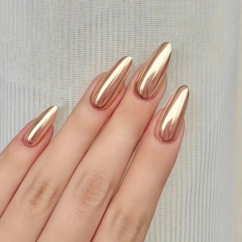 mirror chrome gold christmas nails on almond shape showing perfect reflection finish without grainy texture