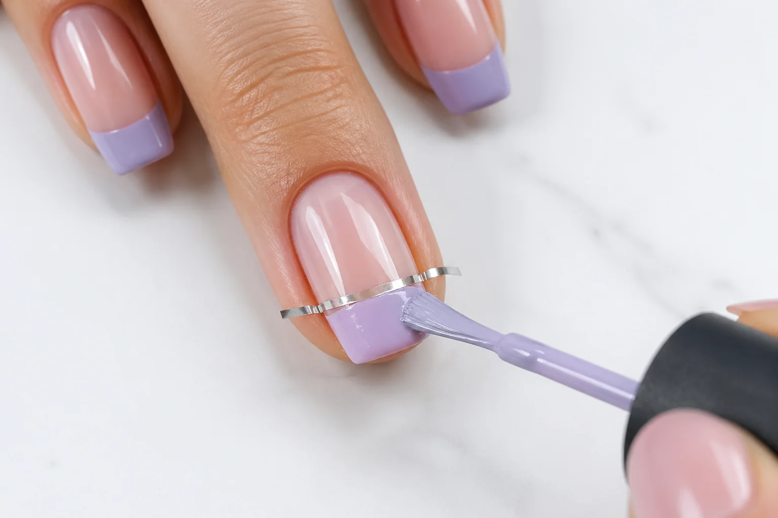 Pastel French tip nails close-up showing lavender and blush coloured tips on nude base with clean tape guide strip line result