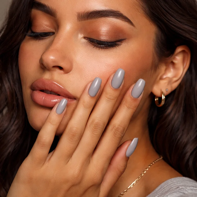Undertone temperature clash showing cool grey-pink nude applied to warm olive skin demonstrating flat grey failure mode in close up nail comparison