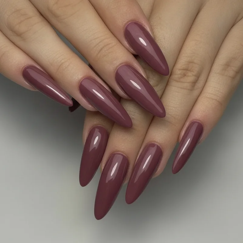 Short coffin nails on fuller fingers showing tapered sides and moderate flat tip in deep rose gel polish medium length