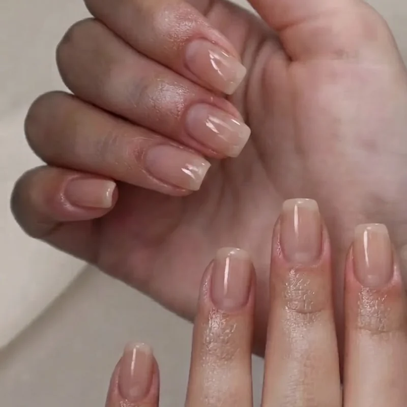 Short squoval nails with a clean French tip and nude polish base for a polished everyday finish